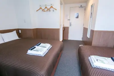 a hotel room with two beds and a bathroom at Oak Hotel Edo in Tokyo