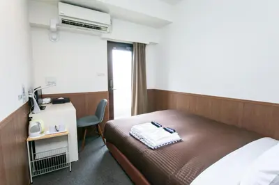 a hotel room with a bed and a desk and a chair at Oak Hotel Edo in Tokyo
