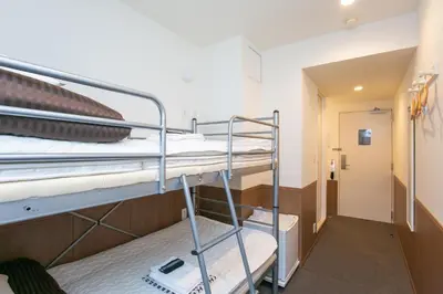 a room with two bunk beds and a hallway at Oak Hotel Edo in Tokyo
