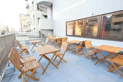 a group of wooden tables and chairs on a balcony at Oak Hotel Edo in Tokyo