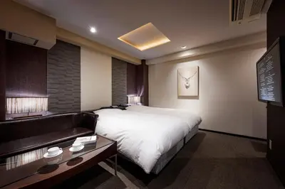 a hotel room with a bed and a couch at Hotel COREST (Adult Only) in Tokyo