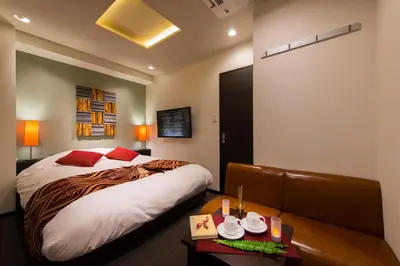 a hotel room with a bed and a couch at Hotel COREST (Adult Only) in Tokyo