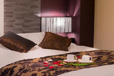 a bed with two cups and a tray with flowers on it at Hotel COREST (Adult Only) in Tokyo