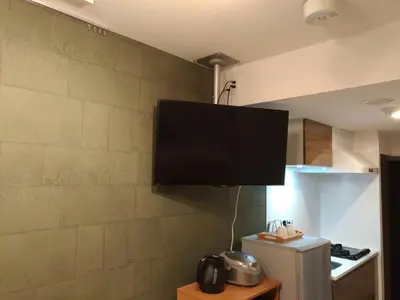 a flat screen tv hanging on a wall in a kitchen at Hotel Axas Nihonbashi in Tokyo