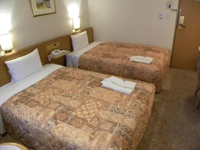 a hotel room with two beds with towels on them at Hotel New Green Okachimachi in Tokyo