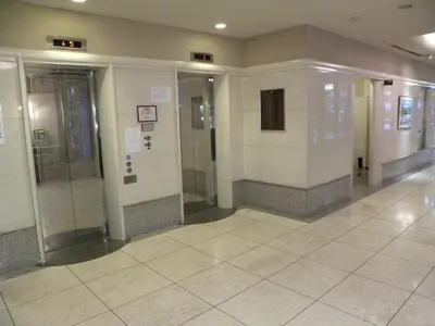 an empty hallway with elevators in a building at Hotel New Green Okachimachi in Tokyo