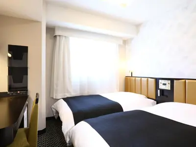 a hotel room with two beds and a window at APA Hotel Iidabashi Ekimae in Tokyo