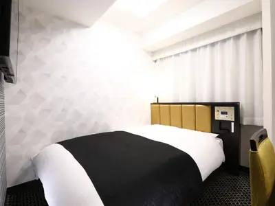 a bedroom with a black and white bed and a window at APA Hotel Iidabashi Ekimae in Tokyo