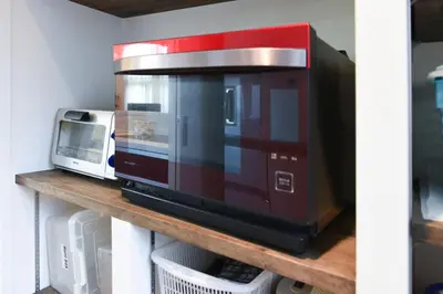 a microwave sitting on top of a wooden shelf at Luxury New House in Tokyo
