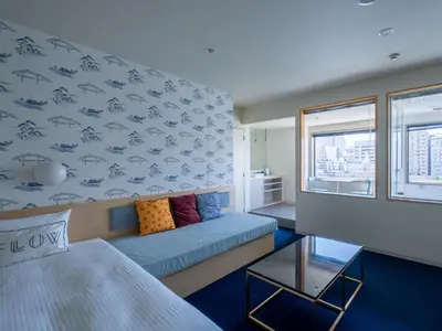 a room with a bed and a couch in a room at LYURO Tokyo Kiyosumi by THE SHARE HOTELS in Tokyo