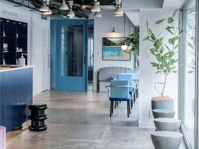 a dining room with blue chairs and a blue door at LYURO Tokyo Kiyosumi by THE SHARE HOTELS in Tokyo