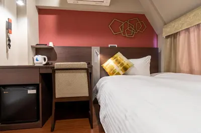 a hotel room with a bed and a desk with a television at Red Roof Inn Kamata / Haneda Tokyo in Tokyo