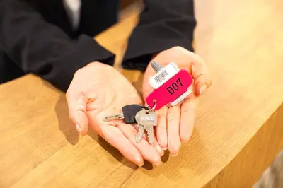 a person holding a pair of keys and a toy car at commun SHIBUYA (Male Only) in Tokyo