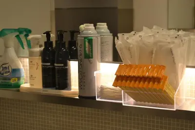 a shelf filled with bottles of alcohol and hot dogs at commun SHIBUYA (Male Only) in Tokyo