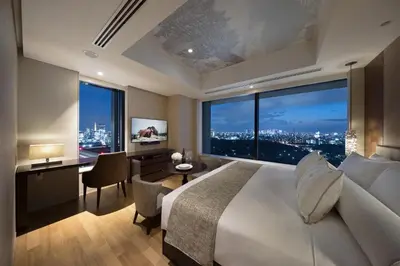 a bedroom with a large bed and a desk and a window at Ascott Marunouchi Tokyo in Tokyo