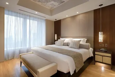 a bedroom with a large white bed and a window at Ascott Marunouchi Tokyo in Tokyo