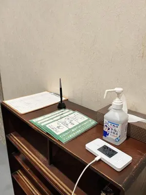 a desk with a phone and a remote control on it at Yanaka Kotobuki Sou in Tokyo