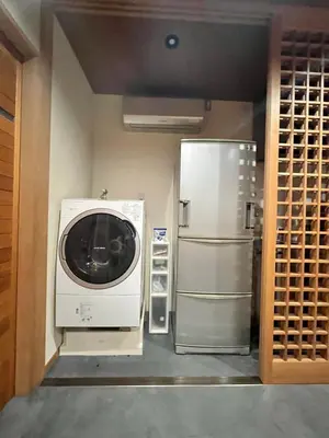 a kitchen with a washing machine and a refrigerator at Yanaka Kotobuki Sou in Tokyo