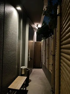 a dark hallway with a bench and a trash can at Yanaka Kotobuki Sou in Tokyo