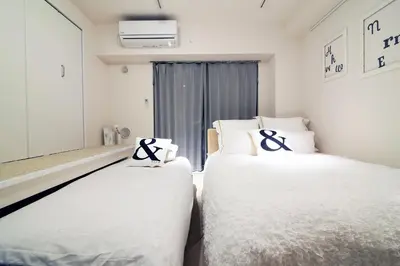 two beds in a room with white sheets and crosses at The Sorapia Tokyo in Tokyo