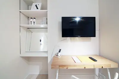a room with a desk with a tv on a wall at The Sorapia Tokyo in Tokyo