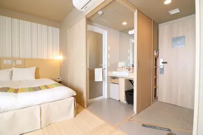 a hotel room with a bed and a bathroom at Hiyori Hotel Maihama in Urayasu
