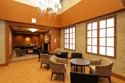 a waiting room with tables and chairs and a chandelier at Hiyori Hotel Maihama in Urayasu
