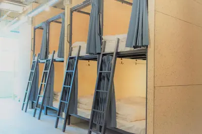 a row of bunk beds in a room with umbrellas at obi Hostel in Tokyo