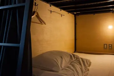 a bedroom with a bed and a wall with a closet at obi Hostel in Tokyo