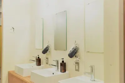 a bathroom with two sinks and two mirrors at obi Hostel in Tokyo