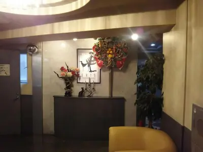 a lobby with a table and a wreath on the wall at Hotel Sting in Tokyo