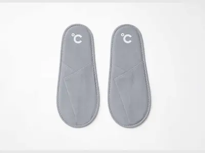 a pair of grey slippers on a white background at Do-C Gotanda in Tokyo