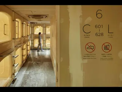 a person standing in a hallway of a train at Do-C Gotanda in Tokyo