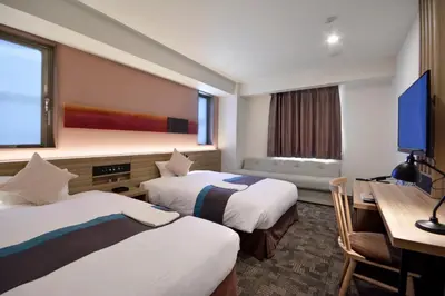 a hotel room with two beds and a desk at Rembrandt Style Tokyo Nishikasai Grande in Tokyo