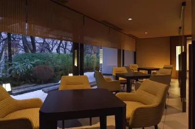 a restaurant with tables and chairs and a large window at Takanawa Hanakohro, a Member of Small Luxury Hotels of the World in Tokyo