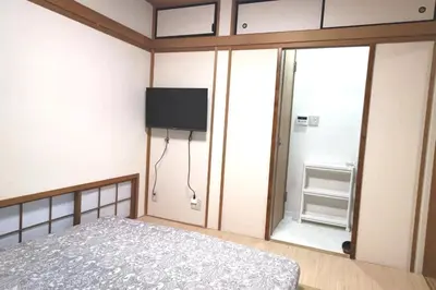 a bedroom with a bed and a flat screen tv at Kiki HouseH --Self Check-in -- Room Number & Password is in the following email in Tokyo