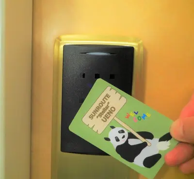 a person holding a sign on a door with a panda on it at Hotel Sunroute Stellar Ueno in Tokyo