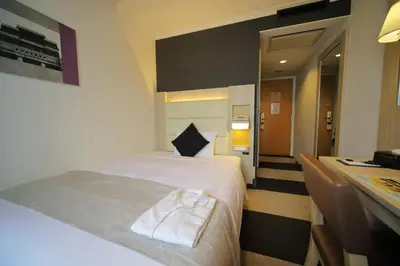 a hotel room with a bed and a desk at Hotel Sunroute Stellar Ueno in Tokyo