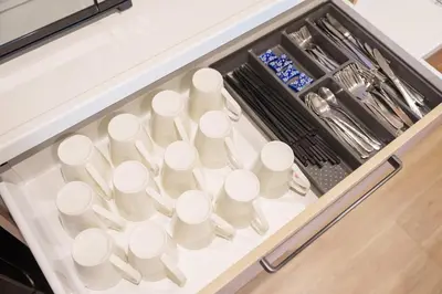 a drawer filled with white cups and utensils at PREMIER suite Shinjuku West 3F 4F in Tokyo
