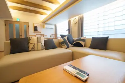 a living room with couches and a remote control on a table at PREMIER suite Shinjuku West 3F 4F in Tokyo