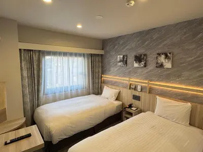 a hotel room with two beds and a window at Akasaka Yoko Hotel in Tokyo