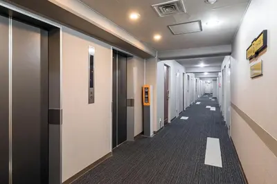 a hallway with a long row of halls with doors at Akasaka Yoko Hotel in Tokyo