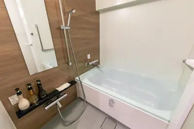a bathroom with a white tub and a mirror at Akasaka Yoko Hotel in Tokyo