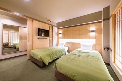 a hotel room with two beds and a mirror at Akasaka Yoko Hotel in Tokyo