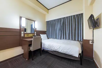 a hotel room with a bed and a desk and a mirror at Akasaka Yoko Hotel in Tokyo