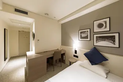 a hotel room with a bed and a desk at Akasaka Yoko Hotel in Tokyo