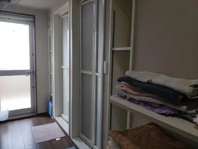 a room with a mirror and some towels on a shelf at Yamate Rest House (Male Only) in Tokyo