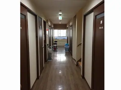 an empty hallway in a hospital with a child standing in the aisle at Yamate Rest House (Male Only) in Tokyo