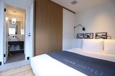 a bedroom with a large bed and a bathroom at TRUNK(HOTEL)CAT STREET in Tokyo