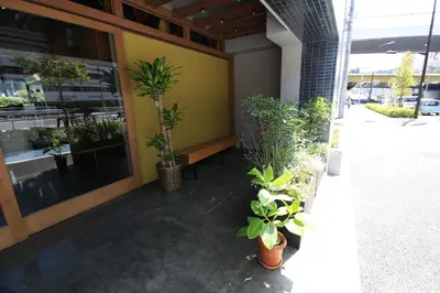 a porch with potted plants in front of a building at Wise Owl Hostels Shibuya in Tokyo